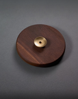 Wooden disc with a gold center on a gray background