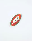 Top view of a ceramic cat lying on a watermelon slice incense holder against a white backdrop.