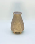 Back view of the Zen Glow Aroma Burner highlighting its textured ceramic surface and circular embossed detail.