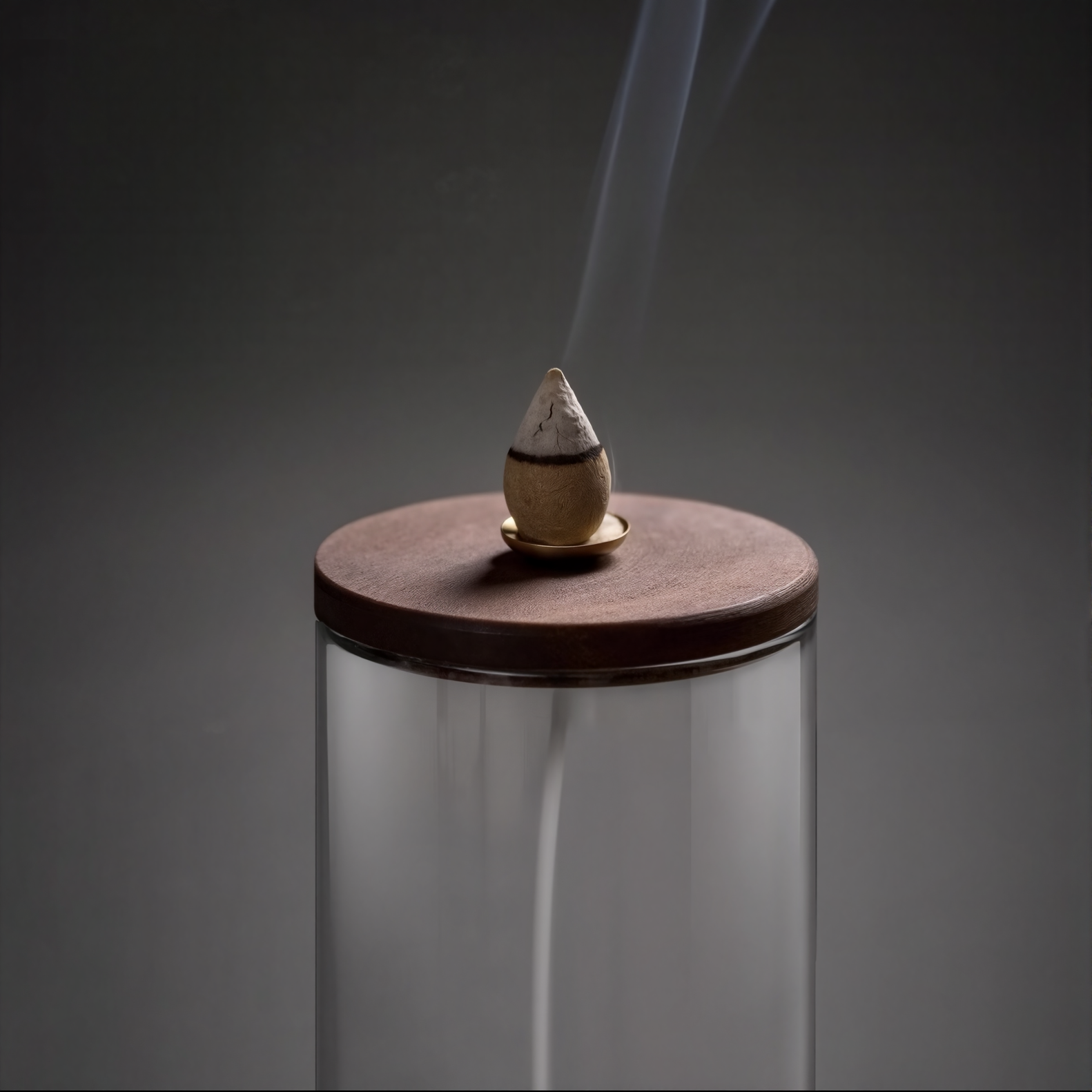 Incense cone burning on a glass stand with a dark background