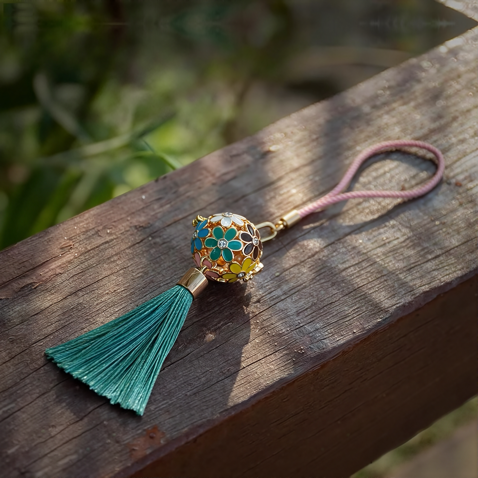 Zen Aroma Flora Bloom Sachet Pendant with golden filigree cage, enamel floral design, and green silky tassel — crafted to hold up to two aroma pellets, blending fragrance with ornamental charm.