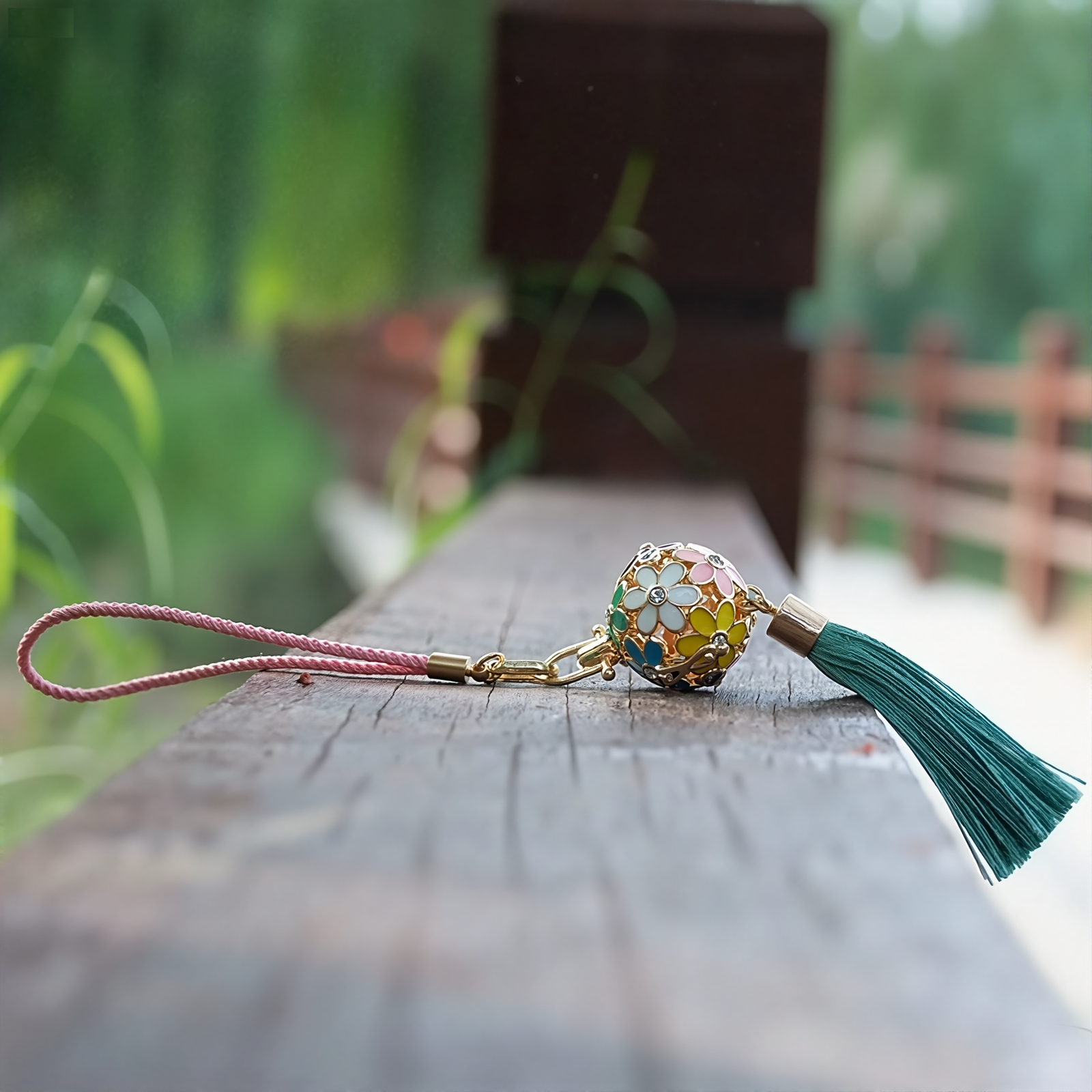 Zen Aroma Flora Bloom Sachet Pendant with golden filigree cage, enamel floral design, and green silky tassel — crafted to hold up to two aroma pellets, blending fragrance with ornamental charm.