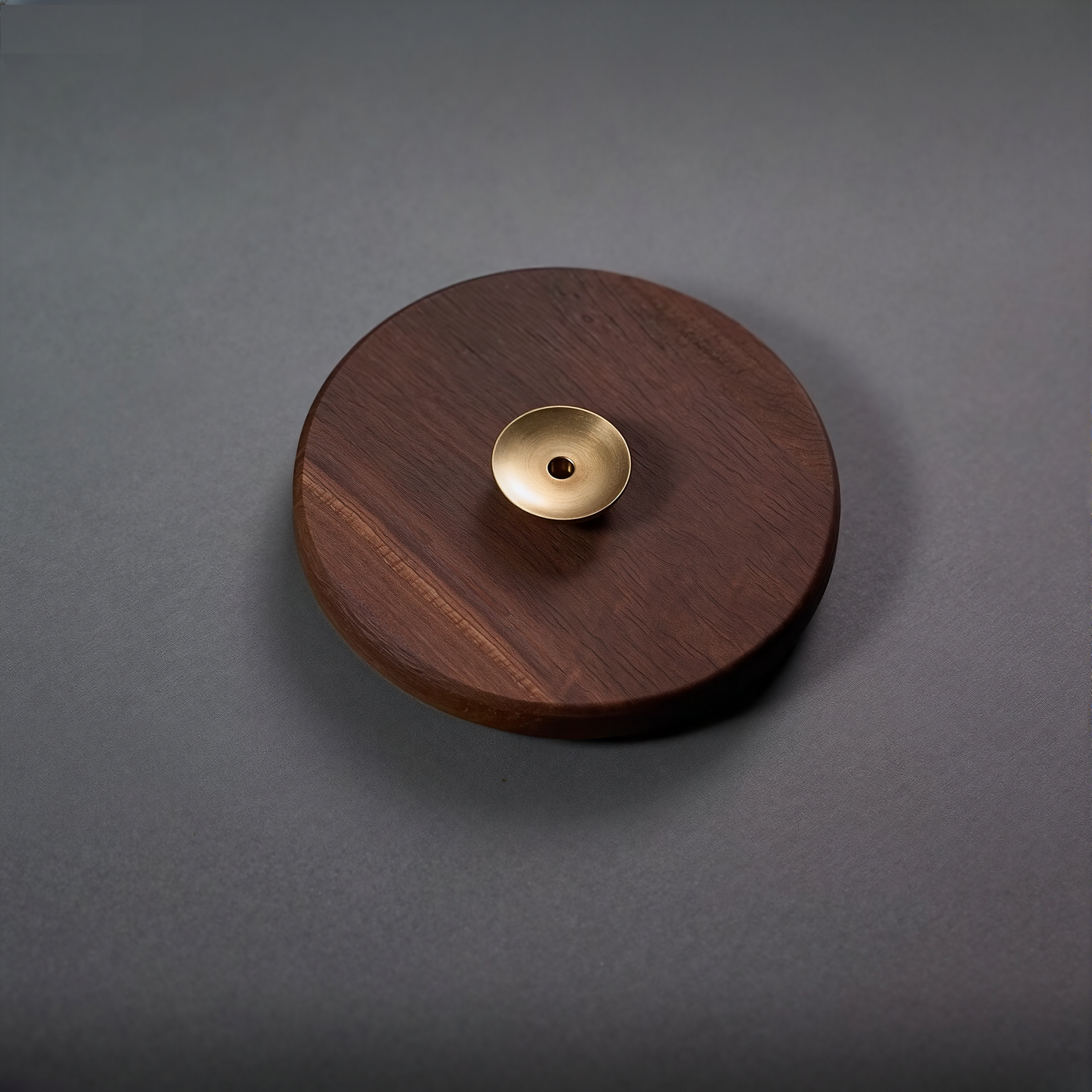 Wooden disc with a gold center on a gray background