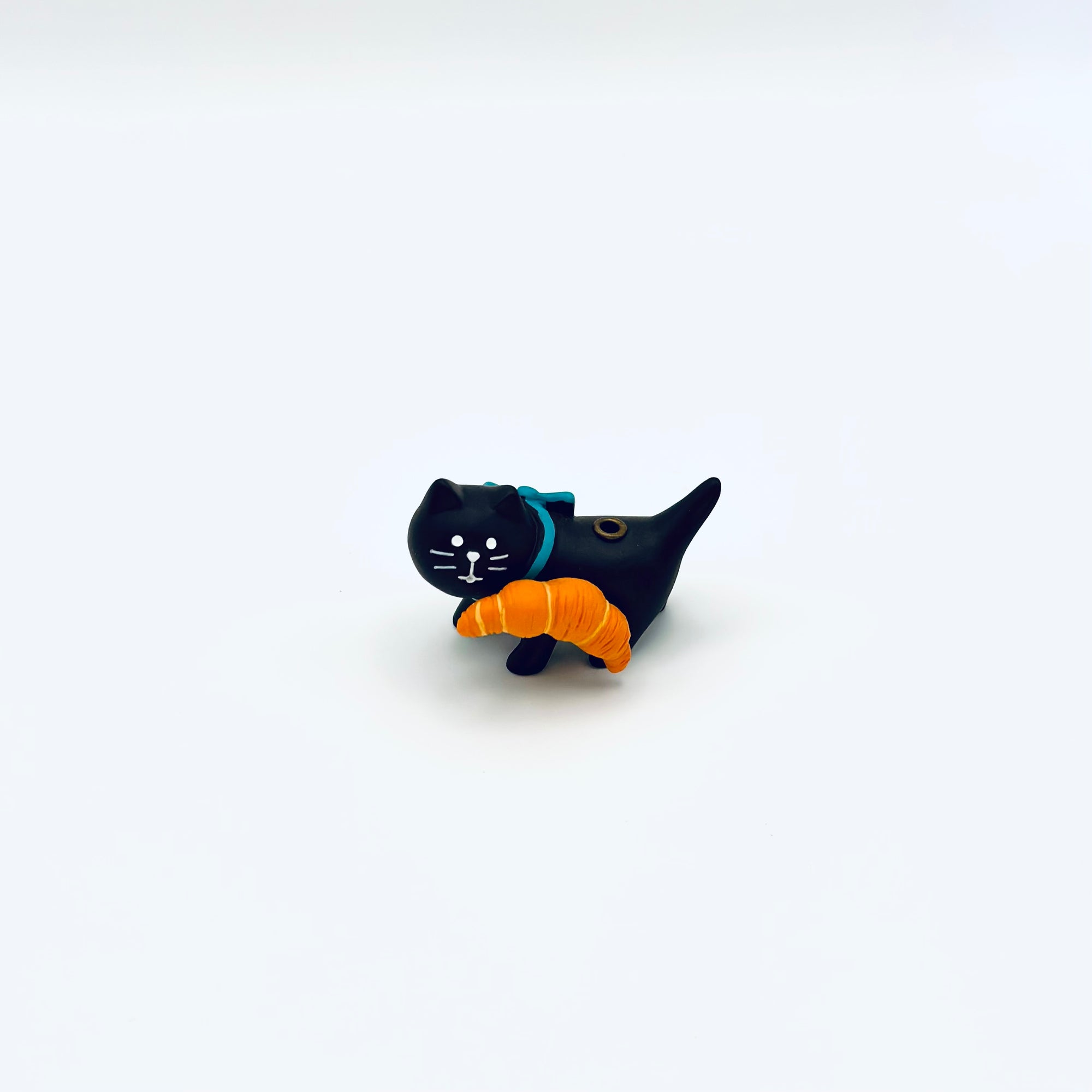 Resin-crafted cat and croissant incense holder, front view on a clean white background.