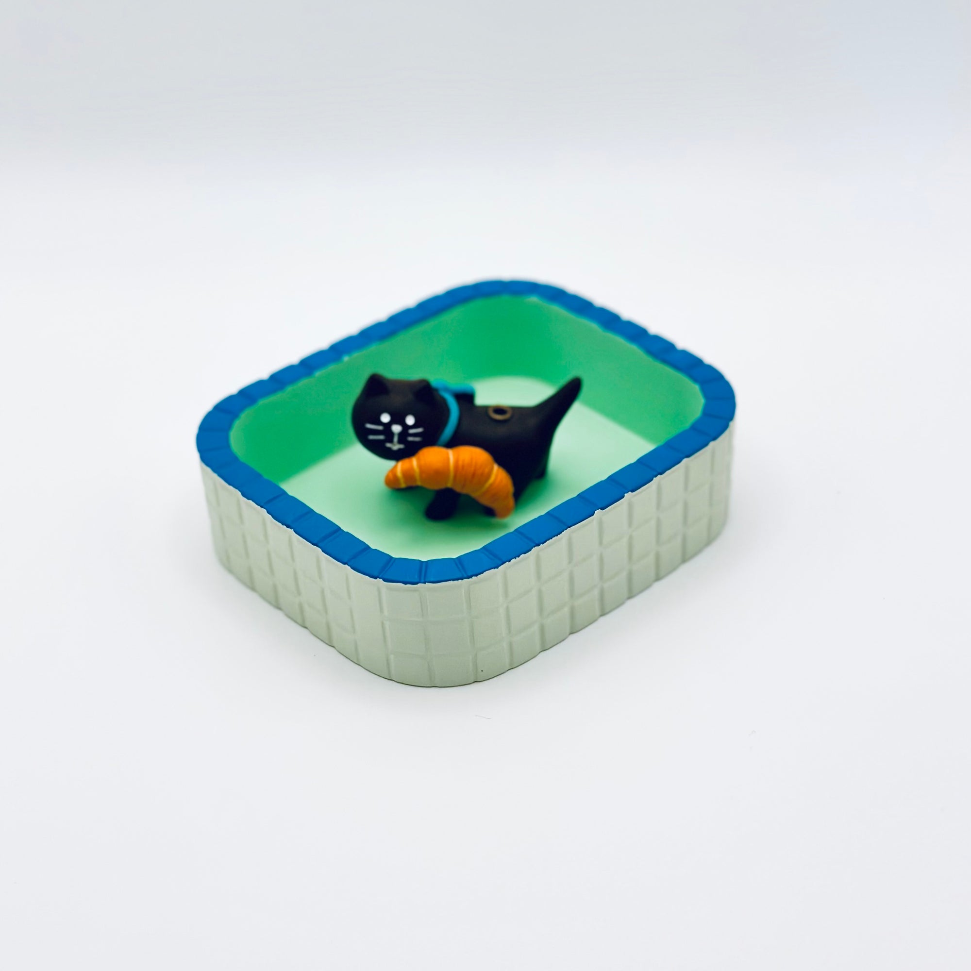 Cat and croissant resin incense holder displayed inside the Purrfect Ash Tub for ash collection.