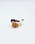 Ceramic cat incense holder holding a pretzel-shaped accessory on a white background.