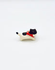 Back view of the ceramic cat incense holder with a red ribbon and pretzel accessory.