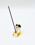 Cat & Towel incense holder in use, holding a vertical incense stick in the center of the resin-crafted figurine.