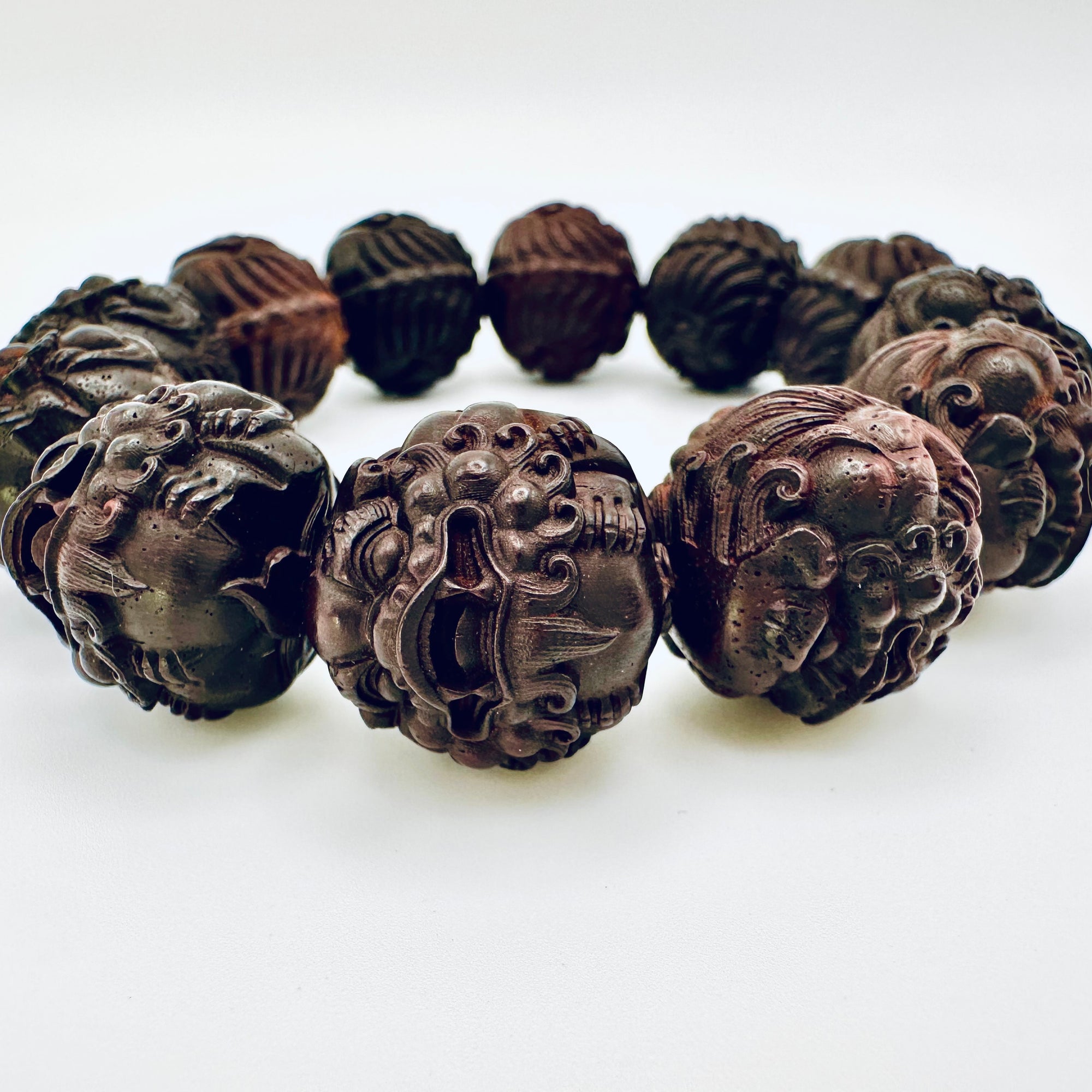 Close-up of the Limited Sacred Edition Guardian Bead Bracelet highlighting the detailed guardian-face carvings on each hand-crafted wooden bead.