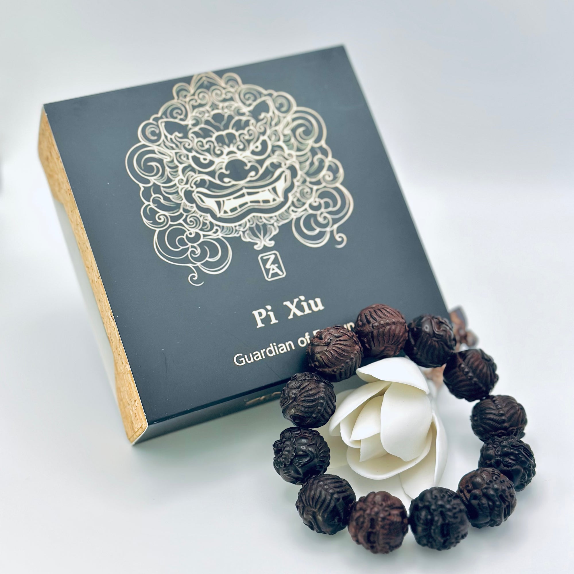 Limited Sacred Edition Guardian Bead Bracelet displayed beside its signature black gift box; handcrafted wooden beads with intricate guardian-carving details.