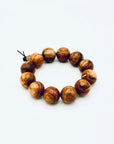 Huanghuali Bead Bracelet (large) crafted from natural rosewood-like hardwood, featuring smooth round beads with rich swirling grain.