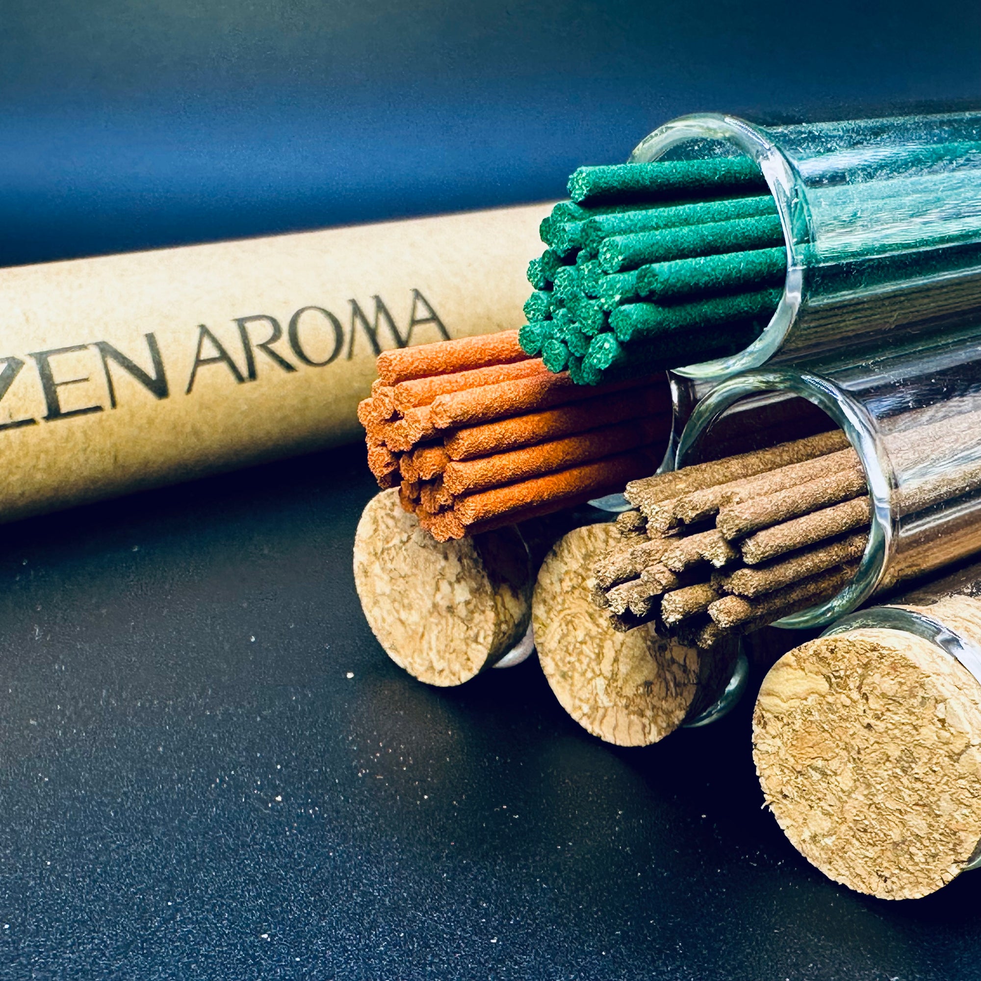 Close-up of Zen Aroma incense sticks in glass tubes with cork lids, showcasing natural textures and rich colors on a dark background.