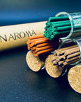 Close-up of Zen Aroma incense sticks in glass tubes with cork lids, showcasing natural textures and rich colors on a dark background.