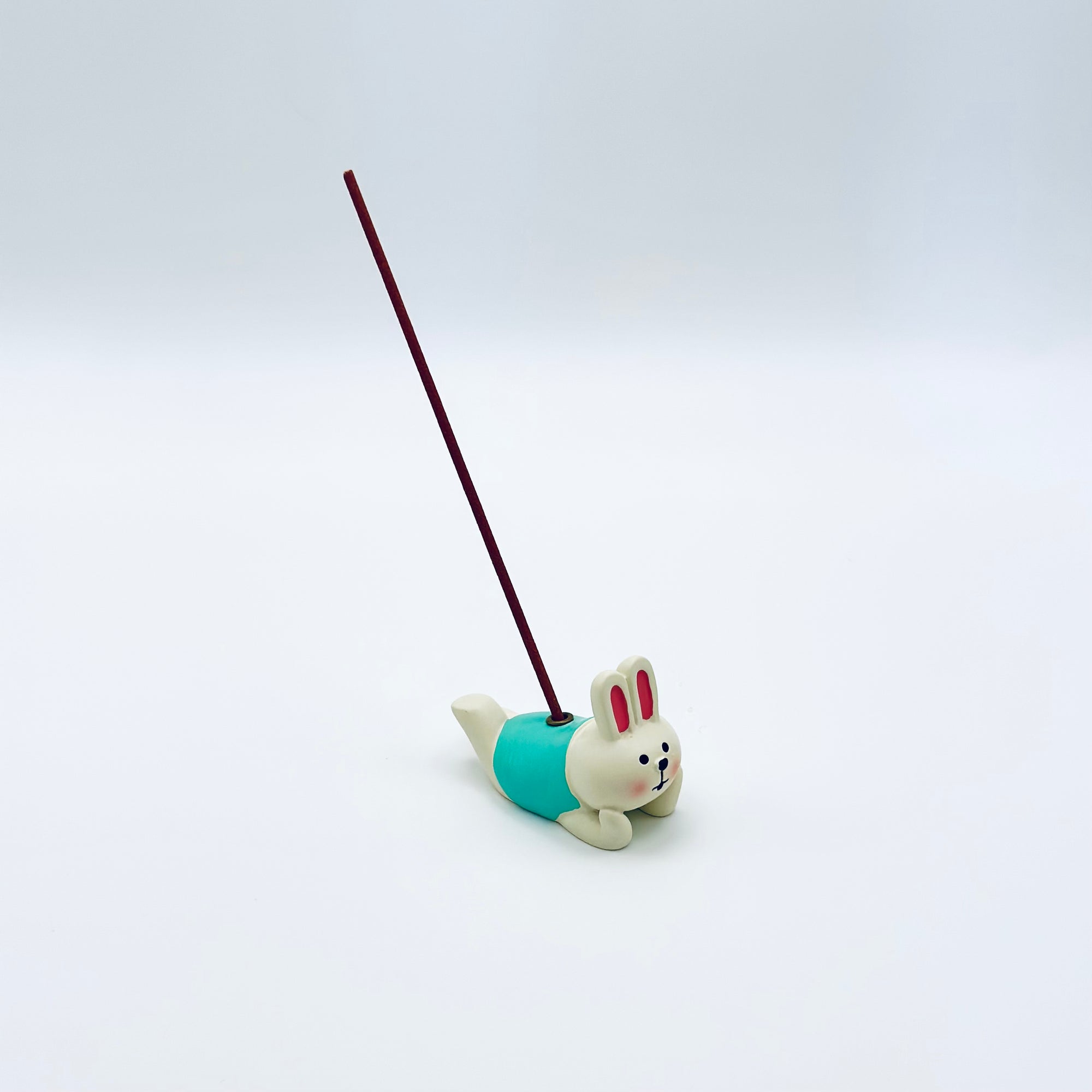 Laying Bunny incense holder with a lit incense stick, featuring a cute resin bunny in a relaxed pose against a clean white background.