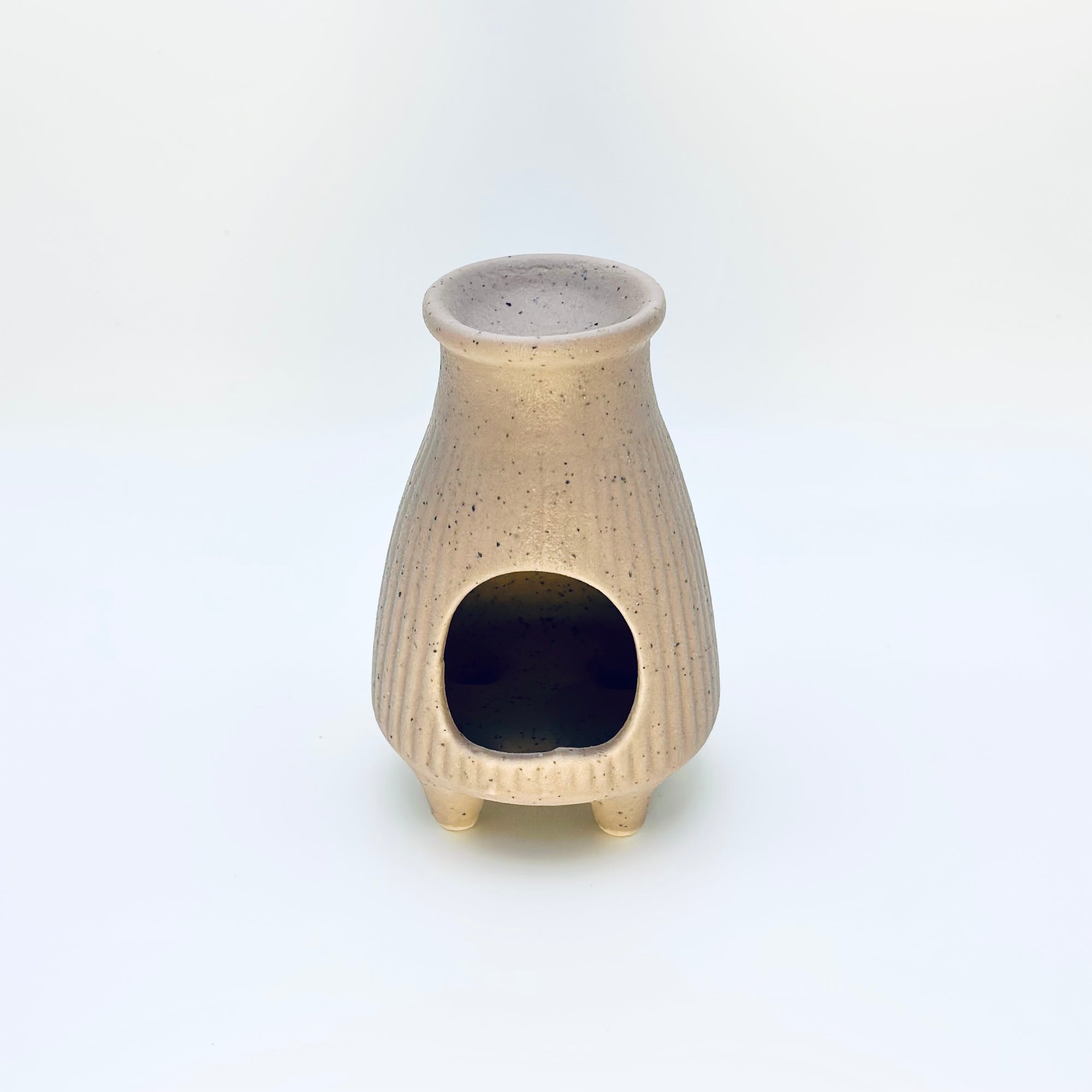 Front view of the Zen Glow Aroma Burner displaying the arched opening and smooth, speckled ceramic finish.