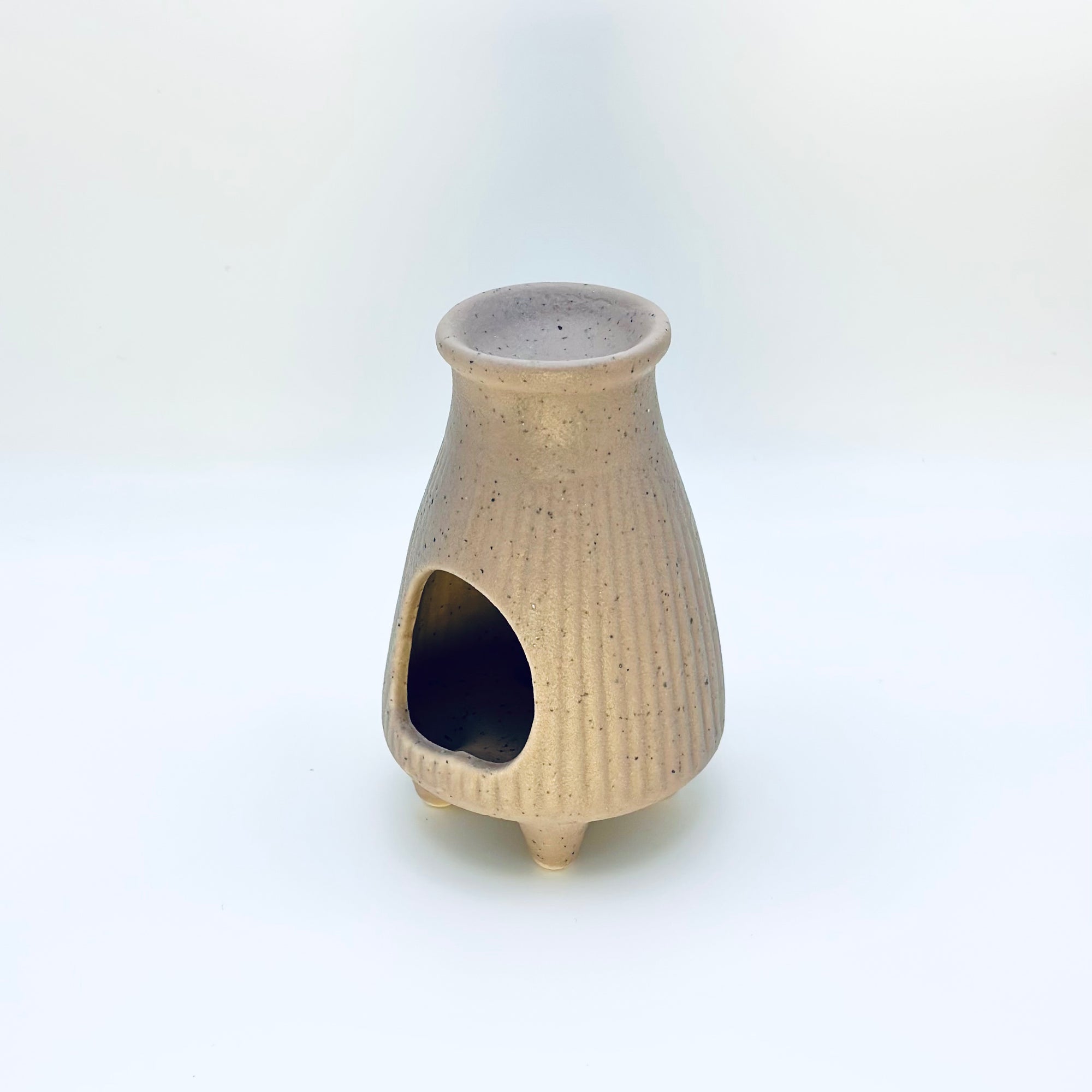 Side view of the Zen Glow Aroma Burner showing the arched candle opening and ribbed ceramic design.