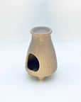 Side view of the Zen Glow Aroma Burner showing the arched candle opening and ribbed ceramic design.