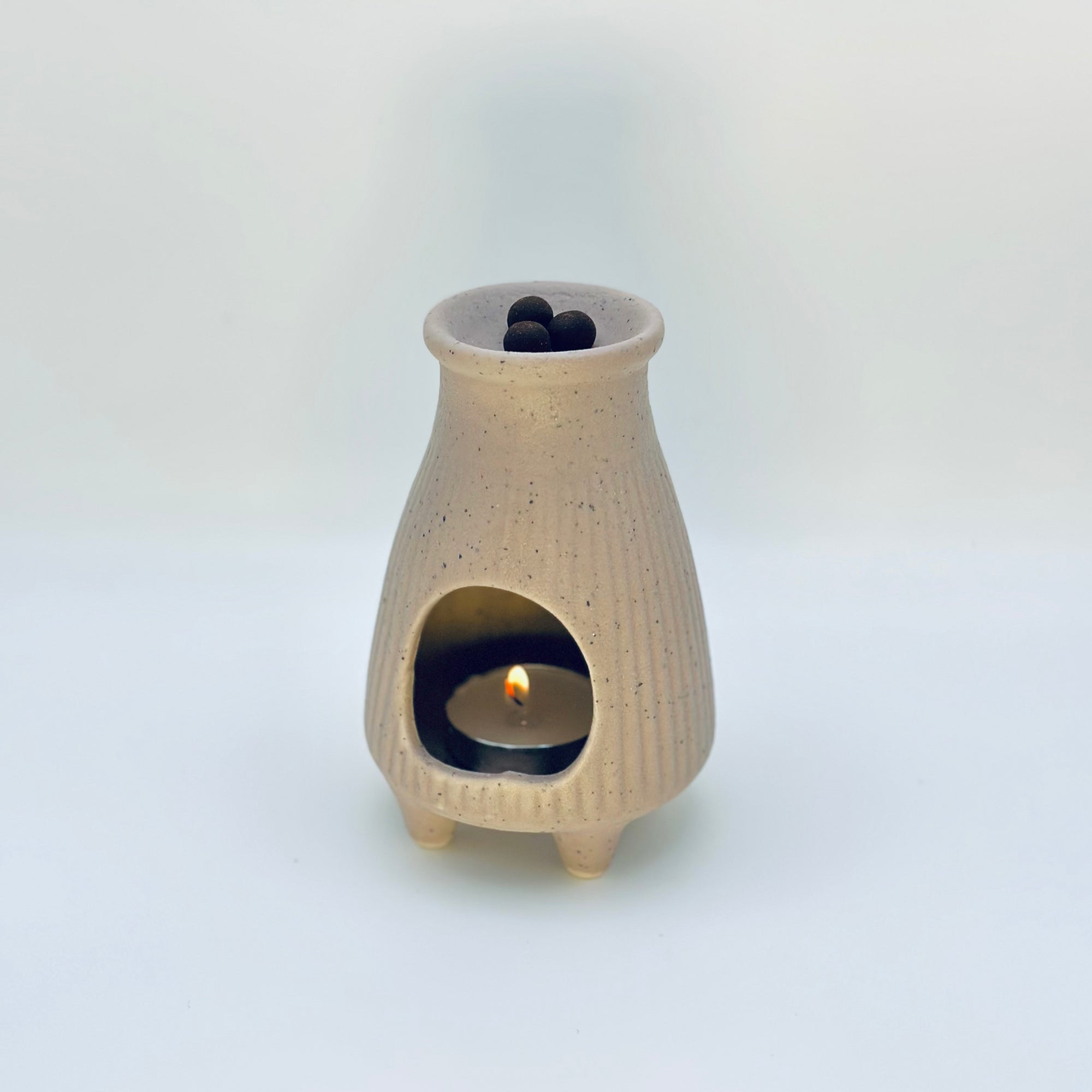 Zen Glow Aroma Burner with tealight glowing inside, gently warming aroma pellets above.