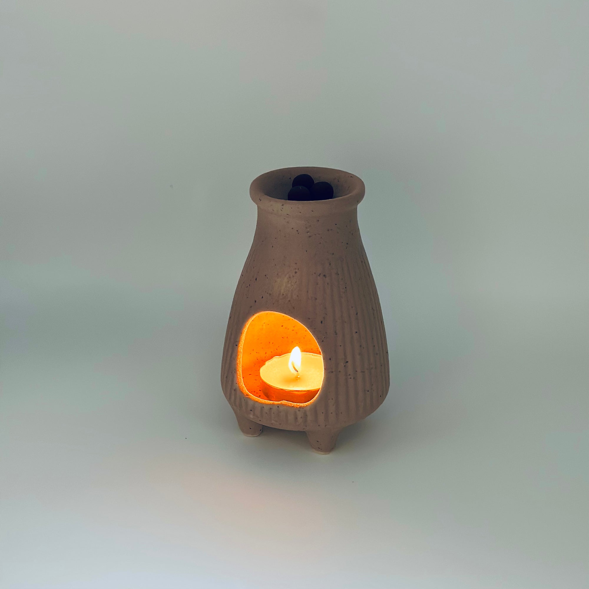 Zen Glow Aroma Burner with a tealight candle inside, showing pellets resting in the top dish.