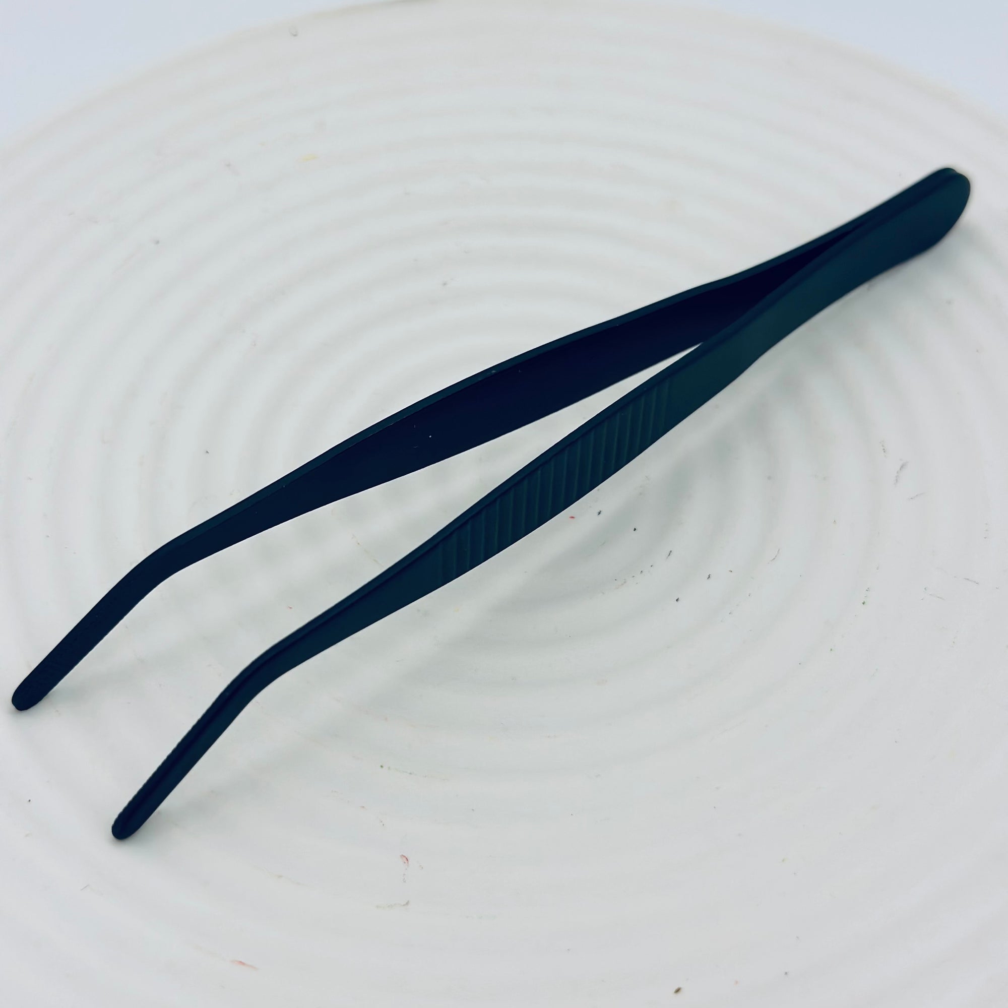 Close-up of the Zen Grip Tweezers, featuring precision angled stainless-steel tips with a matte black finish.