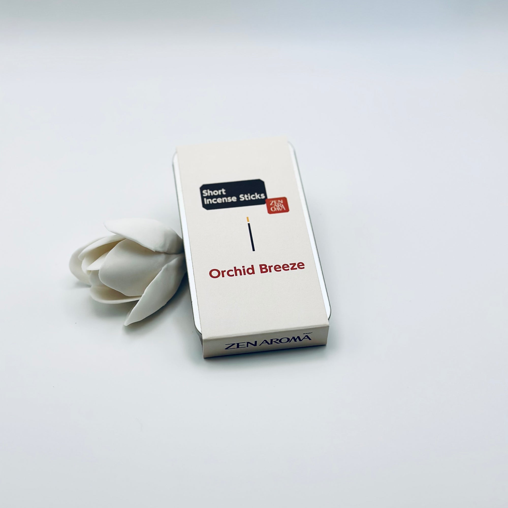 Zen Aroma Orchid Breeze To-Go Incense Kit in beige metal box, styled with a white flower on a clean white background, showcasing minimalist packaging design.