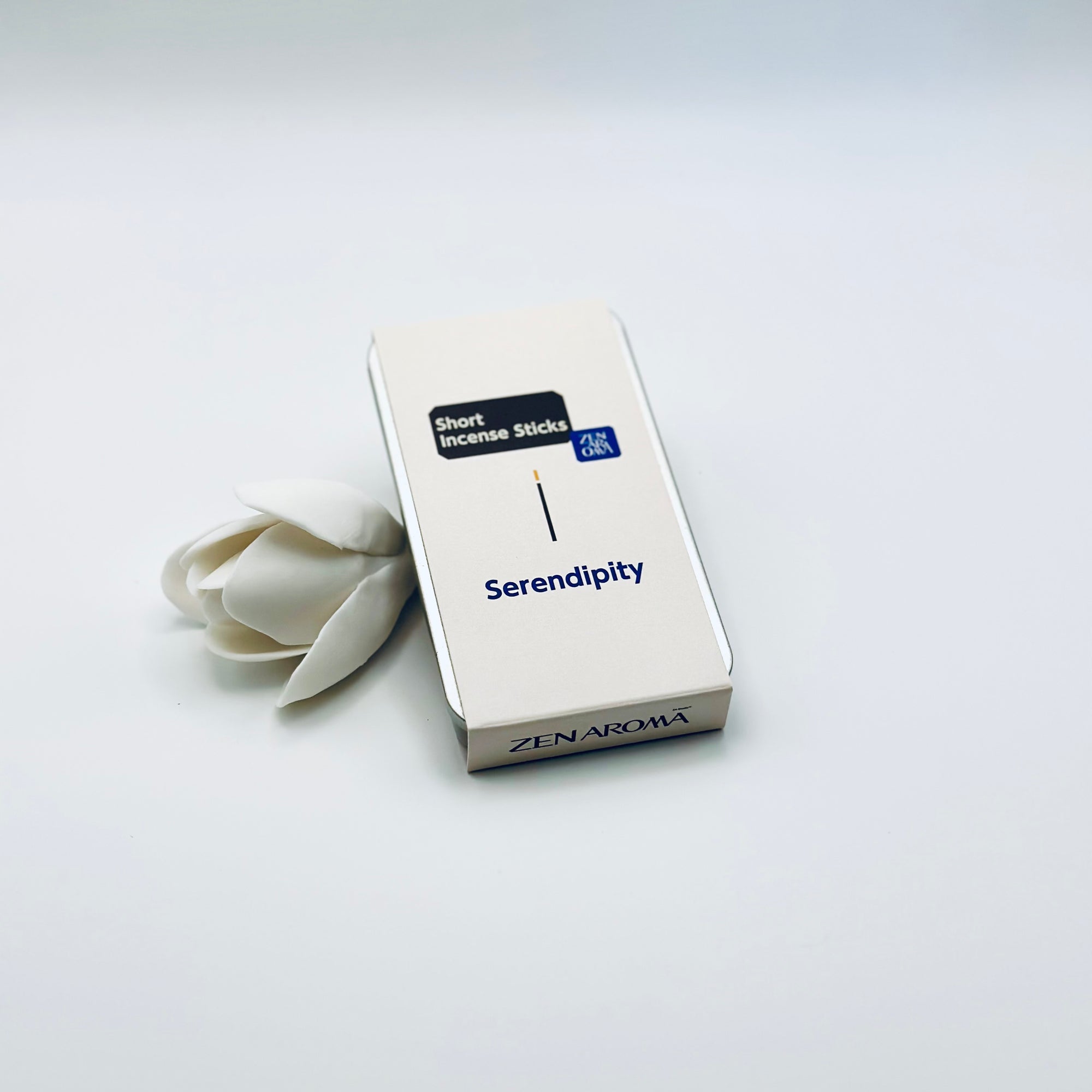Zen Aroma Serendipity To-Go Incense Kit in beige metal box, styled with a white flower on a clean white background, showcasing minimalist packaging design.