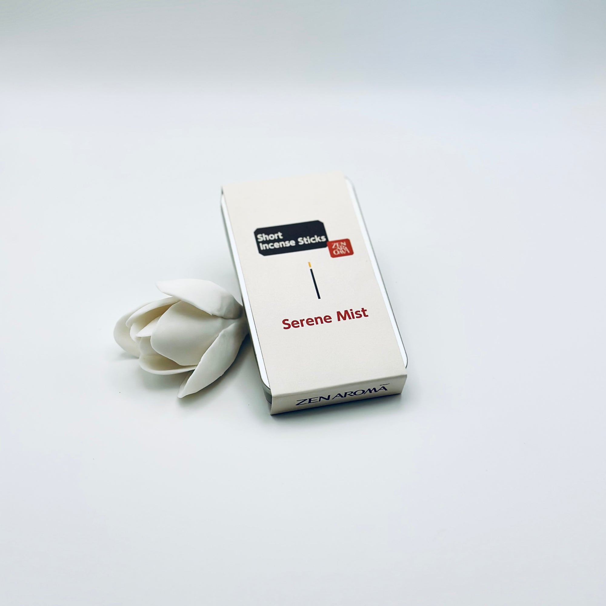 Zen Aroma Serene Mist To-Go Incense Kit in beige metal box, styled with a white flower on a clean white background, showcasing minimalist packaging design.