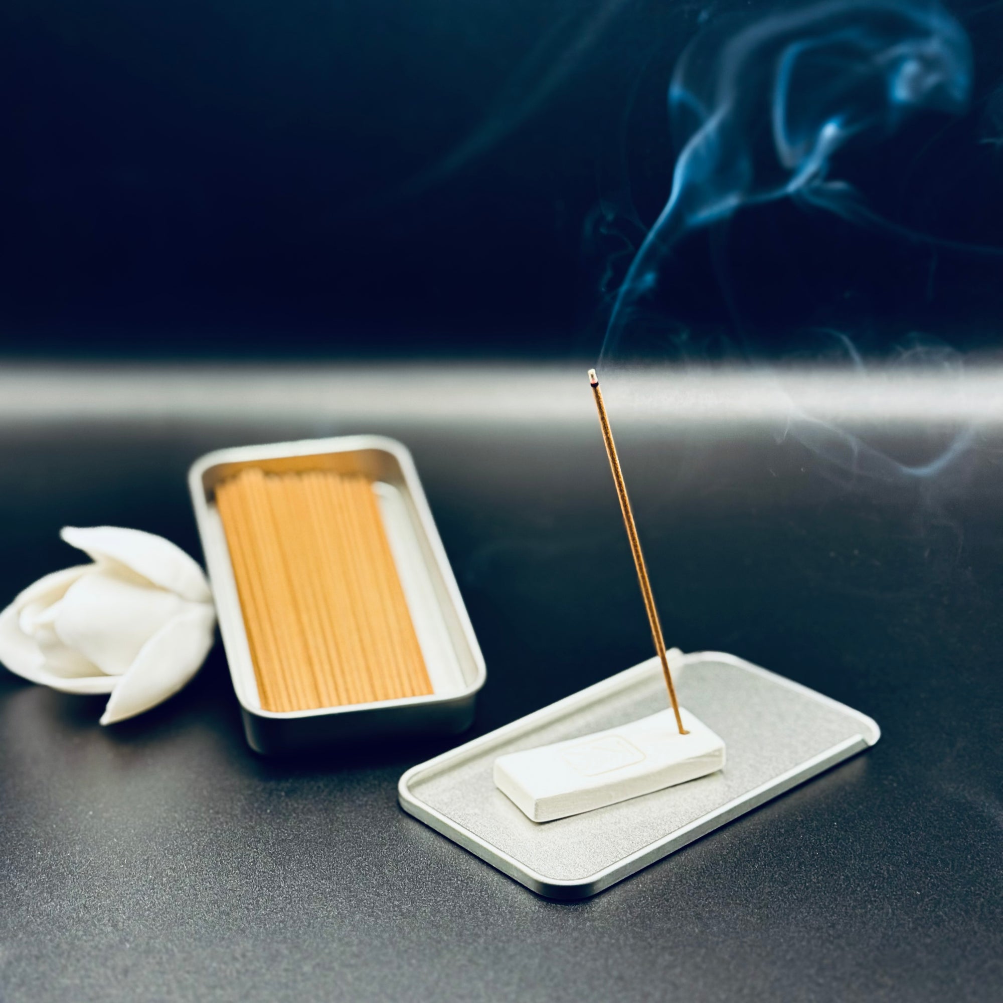 Zen Aroma To-Go Incense Kit in use, with incense stick burning on a minimalist ZA holder and gentle smoke rising against a dark background.