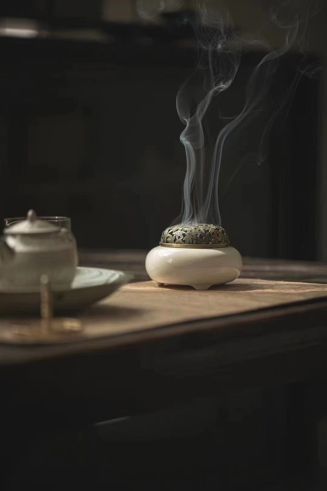 Zen Aroma ceramic incense burner with soft rising smoke – a gentle ritual of fragrance and stillness beside tea